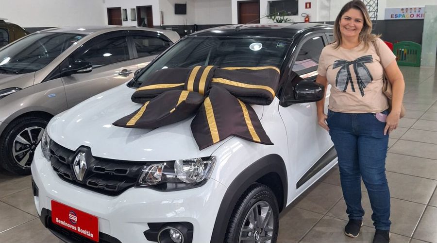 Ana Carolina ao lado do carro novo, com laço no capô